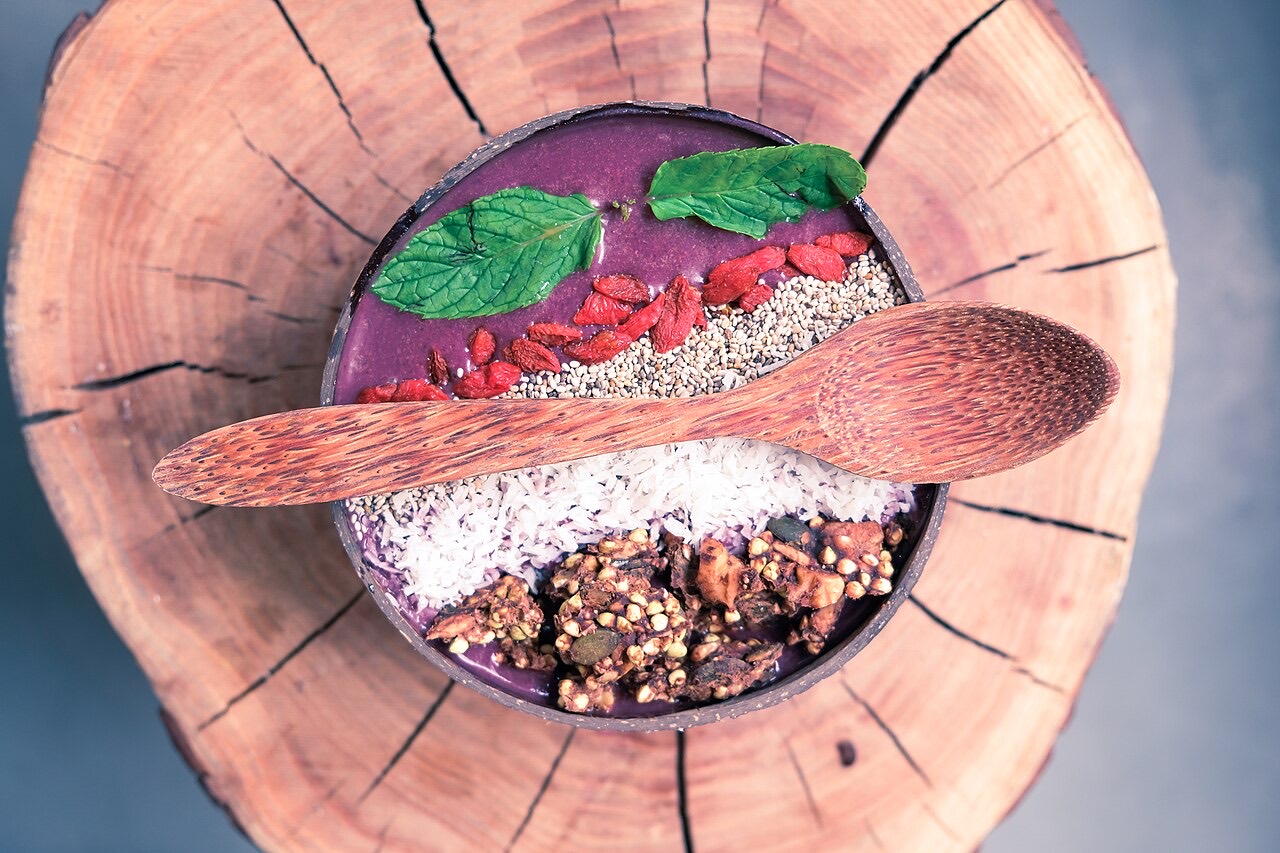 Açaí bowl served in a coconut shell with granola and fruit